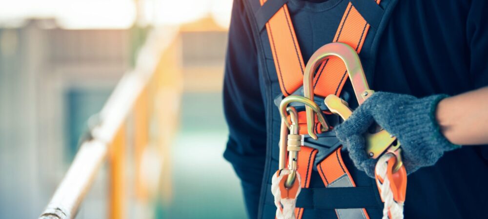 Construction worker wearing safety harness and safety line working at high place